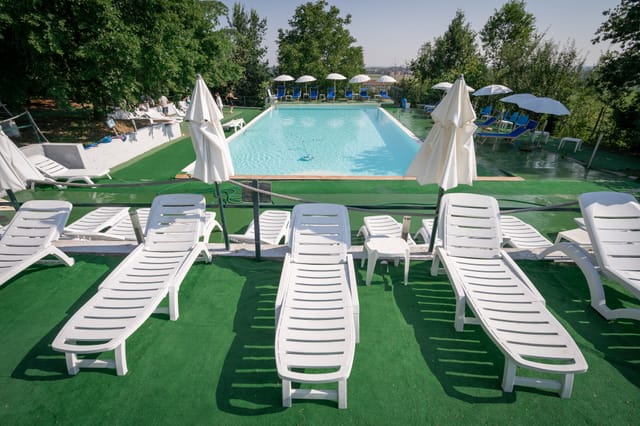 Piscina con lettini nel giardino